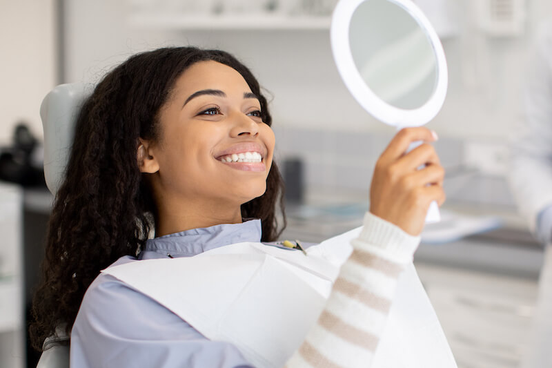 woman smiling into mirror clearview dental round rock
